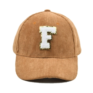Detailansicht des F-Buchstaben-Patches auf einer braunen Cord-Baseballkappe