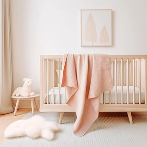 Detailed texture of pink waffle cotton baby blanket draped over a wooden crib rail