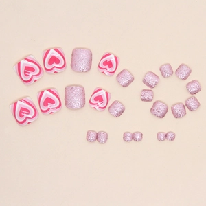Pink glitter press-on toenails featuring heart patterns and gradient sparkle finish