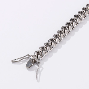 Macro detail of silver Cuban chain bracelet with crystal-studded square clasp closure