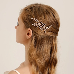 Dettaglio del pettine per capelli da sposa dorato con strass scintillanti a foglia