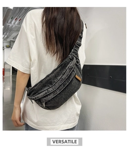 Rear view of a dark grey denim crossbody chest bag featuring a brown leather label detail