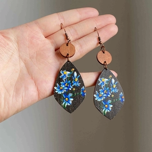Vintage wooden teardrop earrings featuring blue daisy floral prints on dark matte backboard