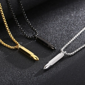 Dettaglio di ciondoli a forma di proiettile in oro, nero e argento con catena veneziana