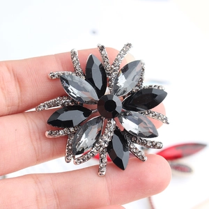 Detail of flower brooch with black marquise gems and white crystals in silver finish