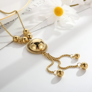 Vintage gold semicircle sphere pendant necklace with tassel chains on a white magazine background