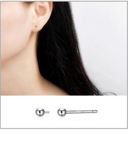 Macro shot of S999 sterling silver stud earrings showing high-polish finish and hallmark