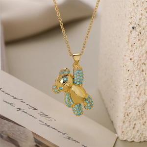 Dettaglio della collana con ciondolo a forma di orso dorato e perle turchesi