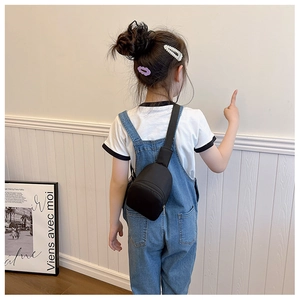 Kid wearing black nylon crossbody chest bag with adjustable strap in a lifestyle shot