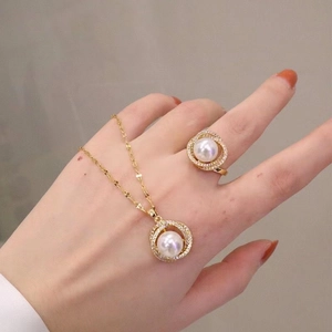 Elegant gold jewelry set with necklace and ring featuring pearls and fine diamond accents