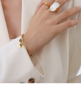 Detailed view of 18K gold plated titanium ring with irregular white seashell on model