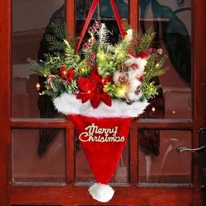 Illuminated Christmas hat door hanging with pine needles and red poinsettia flowers