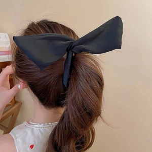 Détail d'une grande pince à cheveux nœud en satin noir style oreilles de lapin
