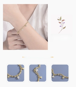 Macro detail of a double-layered gold bracelet with diamond-set flower charms and beads