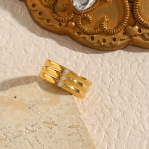 Macro detail of 18K gold-plated triple band ring featuring three inlaid zircon stones