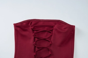 Detail view of burgundy backless dress with lace-up straps and metal eyelet hardware