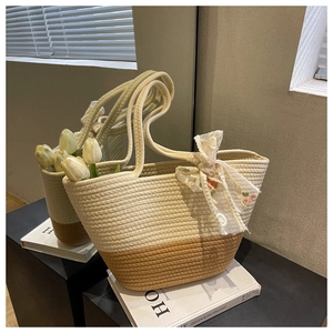 Close-up of woven straw tote bag with elegant white lace flower ribbon decoration