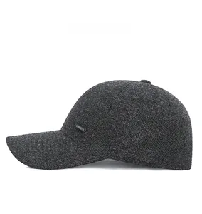 Detail van de winter honkbalpet met metalen sportlabel en dikke grijze geweven textuur