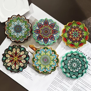 Macro detail of six ceramic coasters with colorful mandala patterns and textured finish