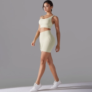 Vista laterale del set fitness senza cuciture crema con reggiseno sportivo e pantaloncini