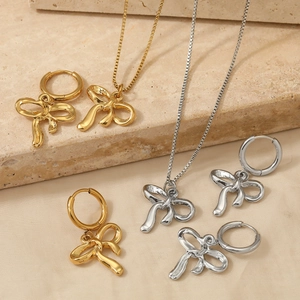 Elegant bow-shaped jewelry set with gold and silver necklaces and hoop earrings