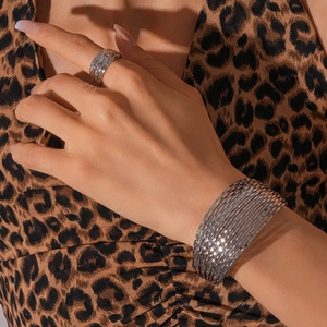 Silver geometric multi-layer open cuff bracelet and ring set worn by a fashion model