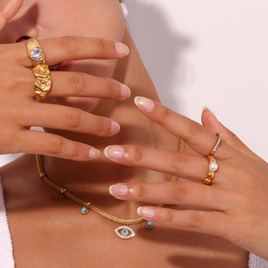 Detailed view of layered 18K gold plated rings with micro-pave hearts and wavy textures