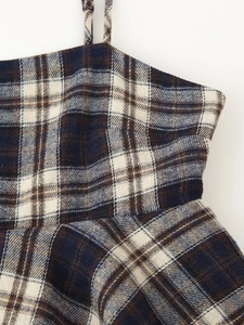 Detail of navy and cream plaid fabric texture with stitched seam and thin strap
