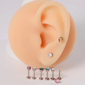 Détail macro de piercings labret en titane G23 avec opale goutte et zircons sertis