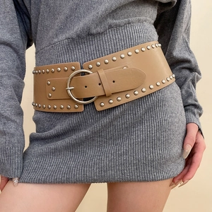 Detail of vintage khaki leather waist belt with double-row metal rivets and silver buckle