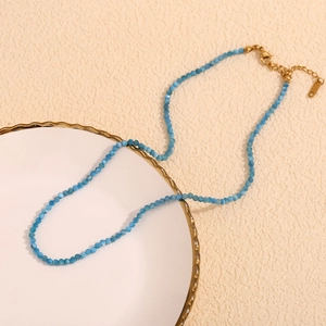 Detail of beaded necklace with blue larimar apatite stones and gold lobster clasp