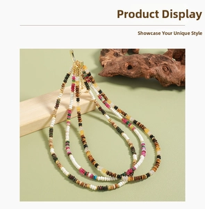 Detail of colorful beaded necklace with tiger eye stones and gold lobster clasp closure
