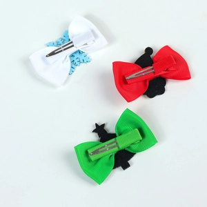 Detail view of holiday bow hair clips in red, white and green with metal alligator clips