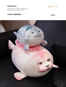 Detail of plush seal pillows in pink and grey with soft embroidered facial features