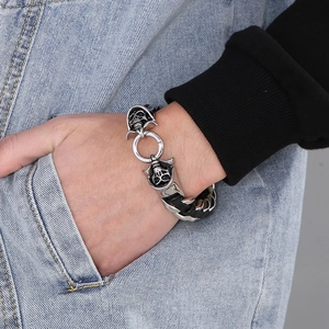 Close-up of punk style skull bracelet featuring woven leather and stainless steel details