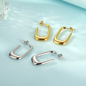 Detail of U-shape hollow earrings in gold and silver finish with silicone backs