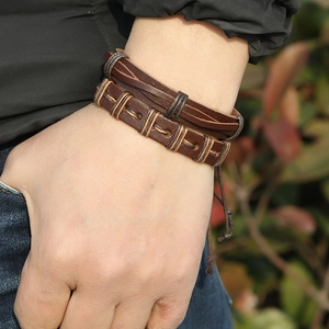 Handmade brown leather woven bracelet set for men and women shown on a wrist