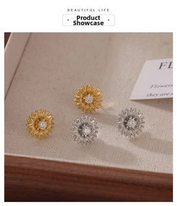 Detailed close-up of sunflower stud earrings in gold and silver with zircon centers