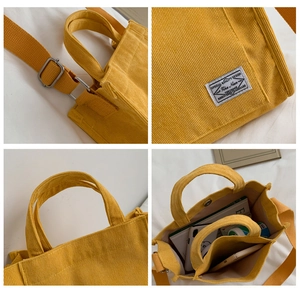 Detail view of yellow corduroy tote showing strap buckle, texture, handle and large capacity