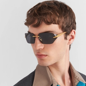 Detailed view of frameless sunglasses with black square lenses and thin gold metal temples