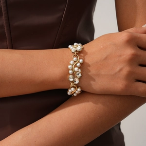 Gros plan d'un bracelet doré vintage avec perles et cristaux brillants au poignet