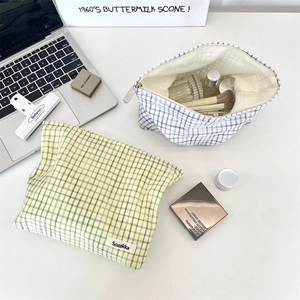 Detailed shot of yellow and blue checkered cotton cosmetic bags with brand labels