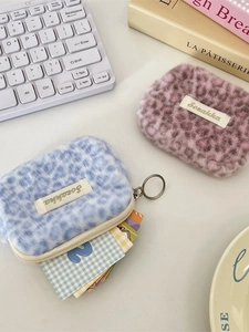 Organizer in peluche leopardato blu e rosa con portachiavi su una scrivania