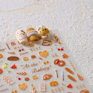 Vue macro des stickers nail art gaufrés thème boulangerie avec croissants et feuilles
