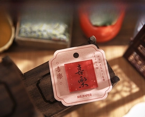 Detail of red acrylic fridge magnet with black Chinese calligraphy and gold leaf accents