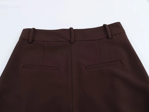 Detailansicht der dunkelbraunen Hose mit Taillenbund und gewebter Stoffstruktur