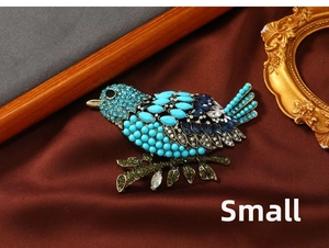Detail of vintage magpie brooch with blue rhinestones on dark satin background