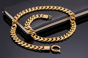 Macro detail of 18K gold-plated curb chain with crystal-encrusted spring clasps