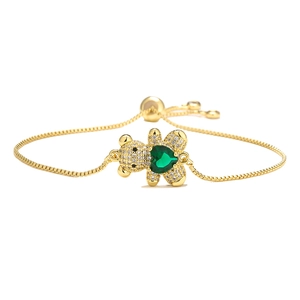 Elegant gold bear bracelet with green heart zircon and pavé crystals on white background