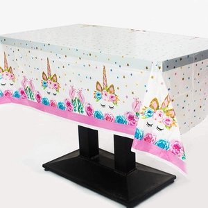 Rainbow unicorn party tablecloth with pink floral patterns and golden stars for birthdays